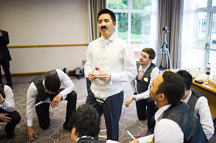 Groom participating in a wedding door game along with the groomsmen