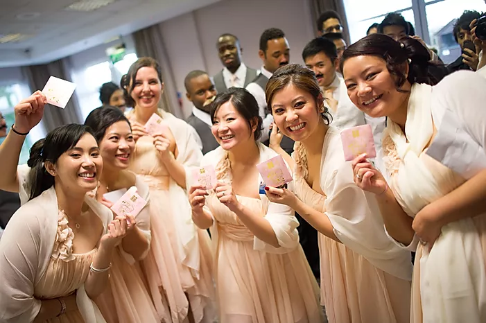 Bridesmaids showing off their money envelope they received from the groom