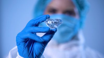 Scientist examining crystal, expert evaluation of precious stone, diamond mining