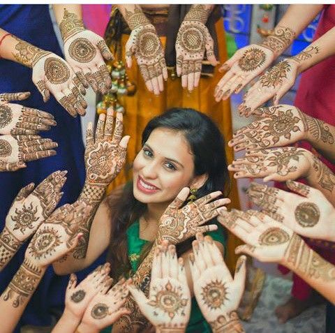 cute bride mehndi poses covered with bridesmaids hands