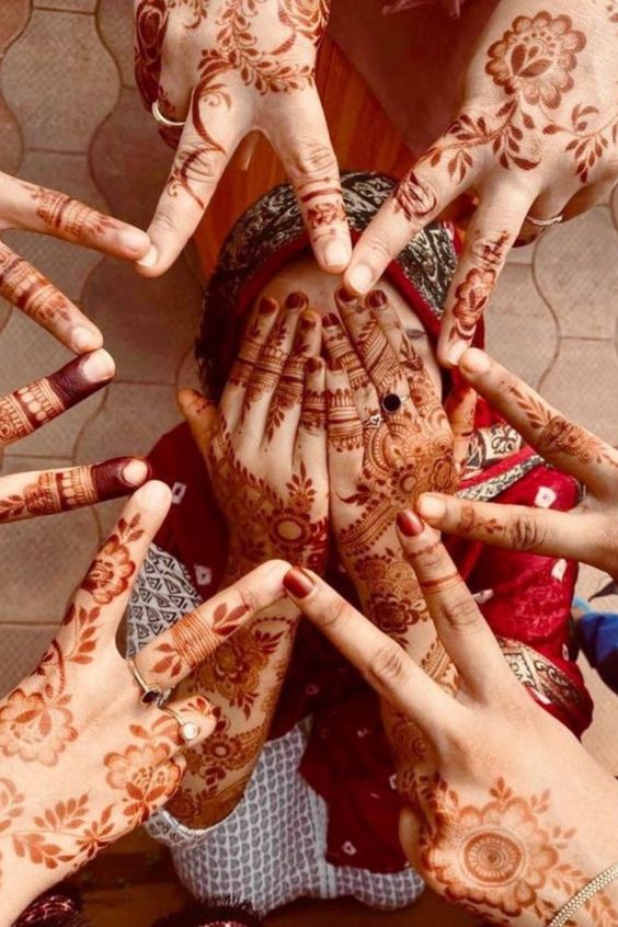 bride hiding face and bridesmaids making star with just the hands for mehndi poses