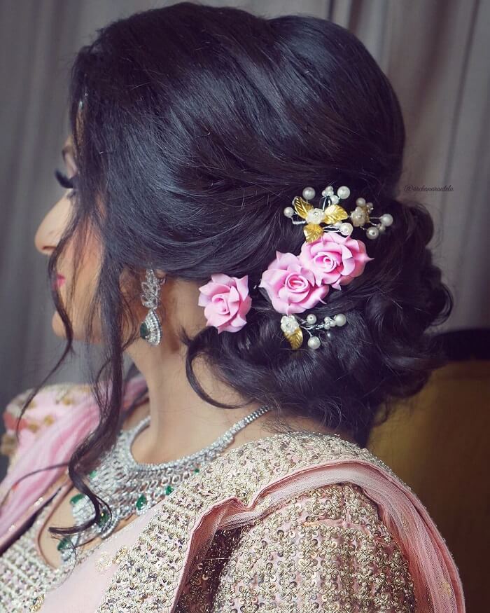 low side braided bun with flower adornments