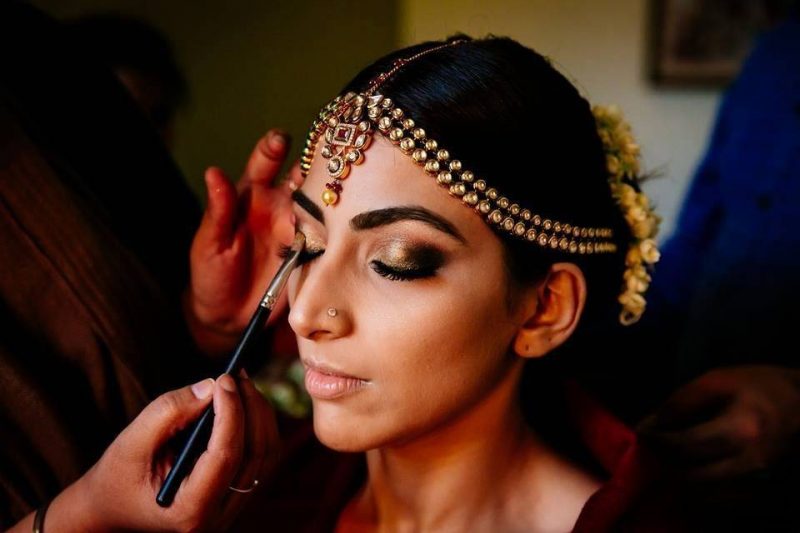 bride getting her eye makeup done - smokey eyes